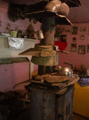 Ray's wood stove provided the only heat for the family during many a winter. His unique design was much admired by many, including a NASA scientist who used a photo of it in a book to demonstrate how Ray fashioned it with heat shields to reflect more heat in the room and tin cans that held water to help humidify the room. (Photo by: Connie Regan-Blake)