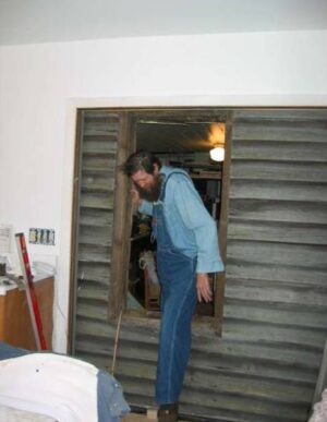 Ted bridging the old cabin and the new addition. (Photo by: Connie Regan-Blake)