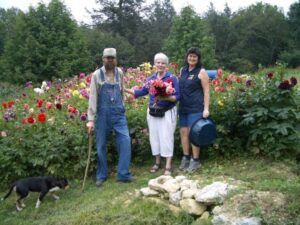 Hicks daughter with Connie Regan-Blake and Ted Hicks by Rosa's field of dahlias. Rosa knows that beauty is as necessary as corn bread.
